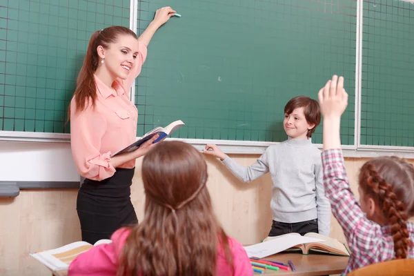 Teacher and pupil standing at blackboard — Stock Photo, Image