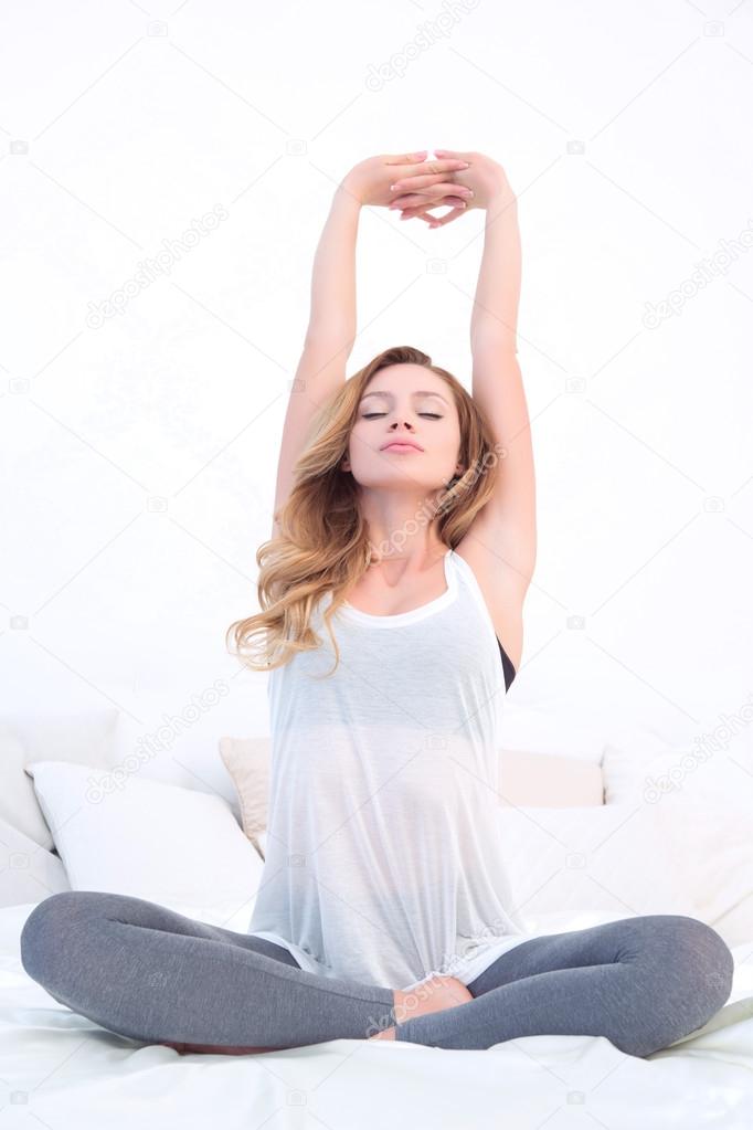 Woman doing stretching in lotus pose