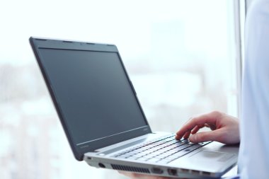 Bilgisayar pencere önünde tutan adam