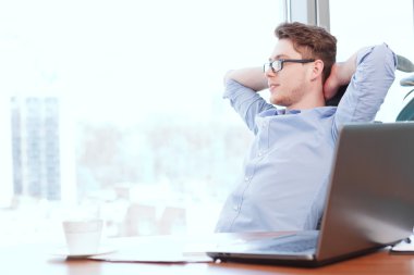 Eller başının arkasına masasında işadamı