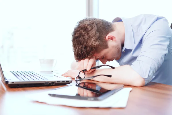 Jungunternehmer schläft auf Schreibtisch — Stockfoto