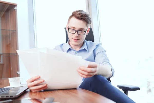 Uomo d'affari guardando attraverso i documenti in ufficio — Foto Stock