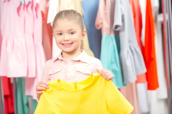 Pequeña chica tratando de un nuevo vestido —  Fotos de Stock