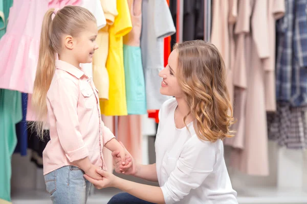 Mãe jovem com filha pequena em uma loja de moda — Fotografia de Stock