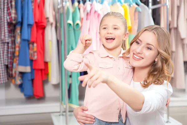 Mãe jovem com filha pequena em uma loja de moda — Fotografia de Stock