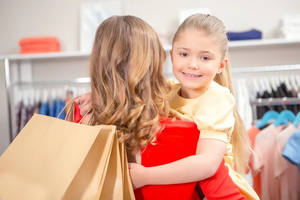 Madre feliz con su hija y un montón de nuevas compras en paquete —  Fotos de Stock