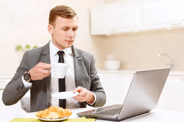 Geschäftsmann trinkt Kaffee und arbeitet am Computer — Stockfoto