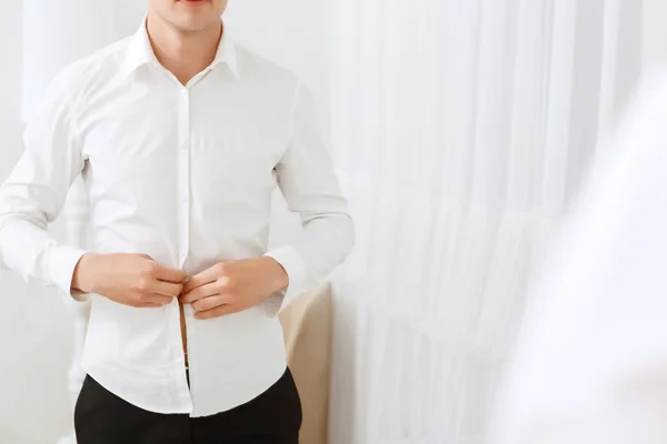 Gros plan de l'homme boutonnage chemise blanche — Photo