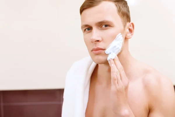 Homem de topless aplicando meio de barbear no rosto — Fotografia de Stock