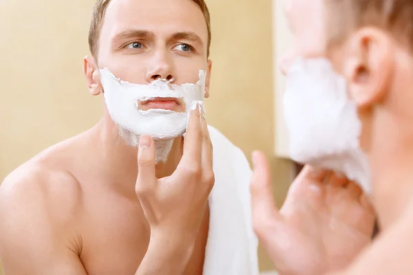 Topless man applying mean of shaving on face — Stock Photo, Image