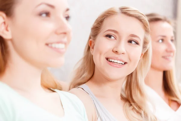 Belle ragazze sedute di fila — Foto Stock