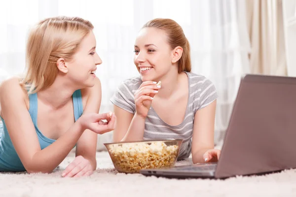 Two young girls eating popcorn — Stock Photo, Image