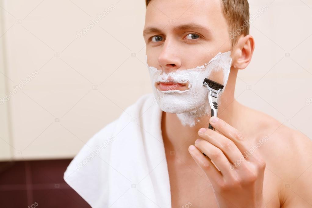Man shaving in front of mirror