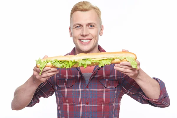 Pria tersenyum berdiri dengan roti lapis panjang — Stok Foto