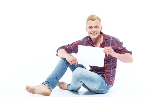 Чоловік сидить на підлозі з аркушем паперу — стокове фото