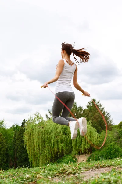 Junge schlanke Frau springt in Park — Stockfoto