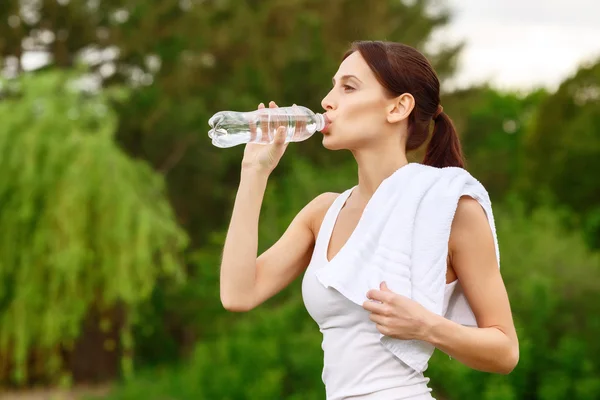 Gadis cantik minum air di taman — Stok Foto