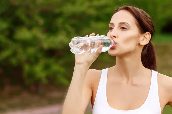 Gadis cantik minum air di taman — Stok Foto