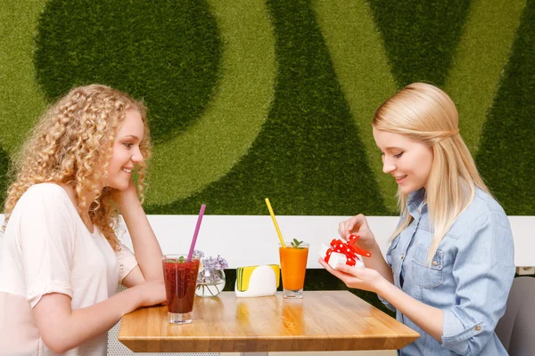 Duas meninas no café com presente — Fotografia de Stock