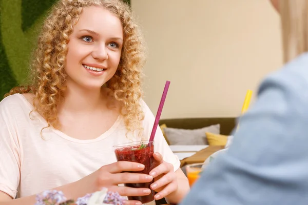 Leende flicka håller cocktail i café — Stockfoto