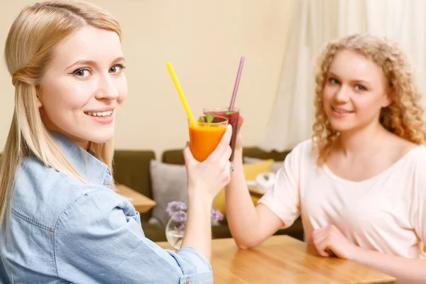 Két nő csengő üvegek, a kávézóban koktélokat — Stock Fotó