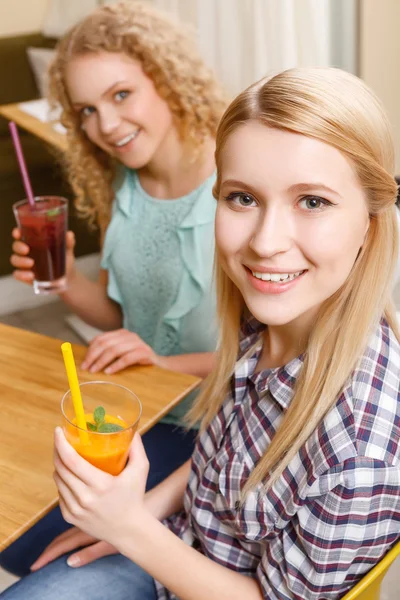 Dos chicas sonrientes sosteniendo cócteles — Foto de Stock