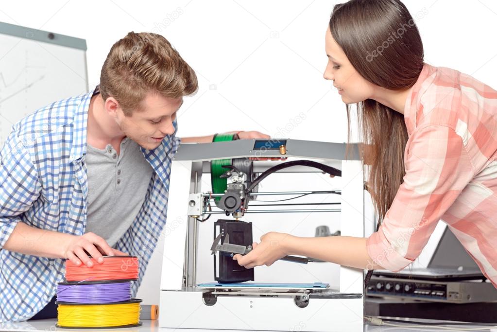 Two students with three-dimensional printer