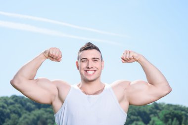 Yakışıklı sporcu açık havada egzersizleri yapıyor