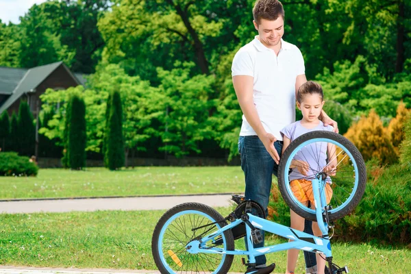 Père enseignant à sa fille à faire du vélo — Photo