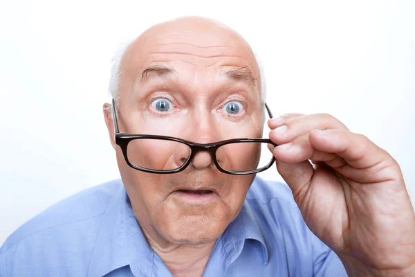 Surprised grandfather holding glasses — Stock Photo, Image