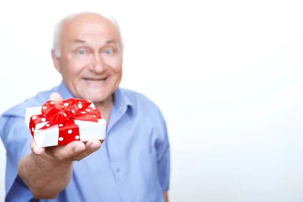 Позитивный дедушка держит подарок — стоковое фото