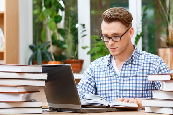 Young student working in a library — Stock Photo, Image