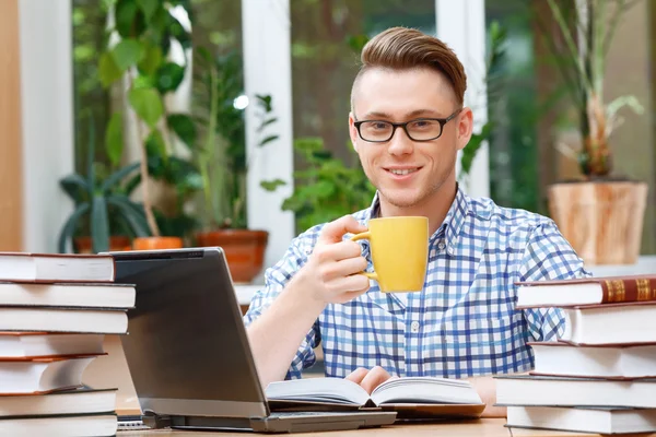 Młody student pracuje w bibliotece — Zdjęcie stockowe