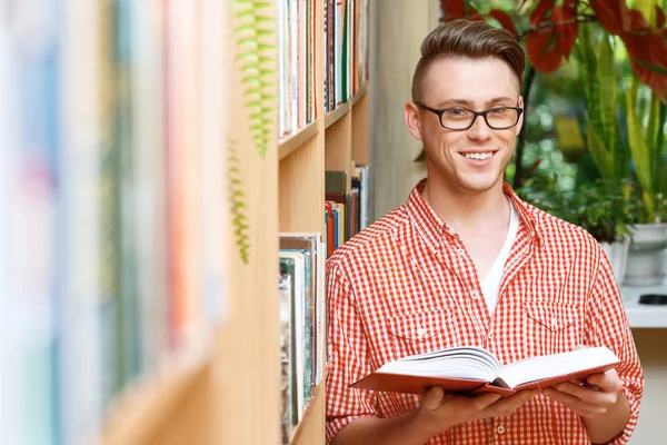 Studente intelligente in una biblioteca — Foto Stock