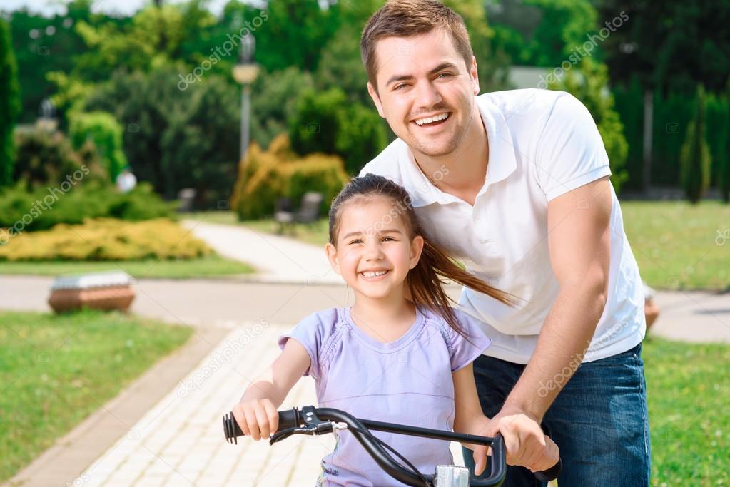 Father teaching daughter to ride a bike