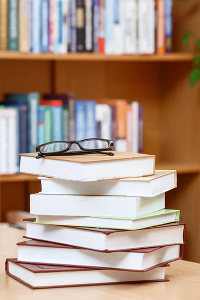 Livros na mesa em uma biblioteca — Fotografia de Stock