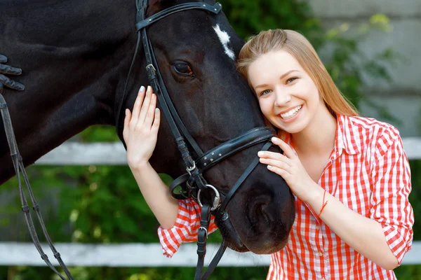 Smiling girl embracing the horse — Stock Photo, Image