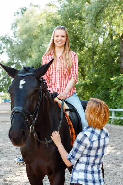 Smiling girl sitting in the saddle — Stock Photo, Image