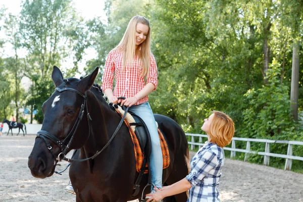 Smiling girl sitting in the saddle — Stock Photo, Image