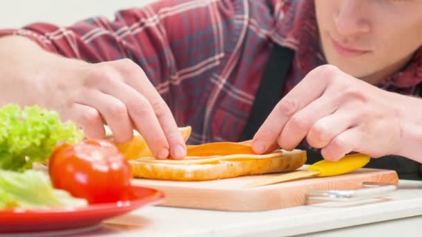 サンドイッチにレタスの葉を追加する男のクローズ アップ — ストック動画