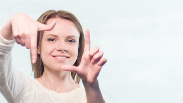 Pretty woman showing frame with her fingers — Stock Video