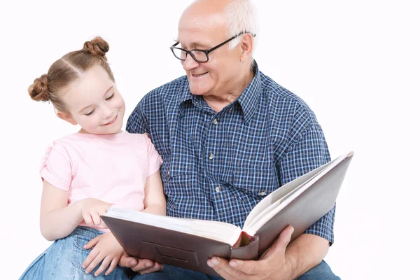 Grootvader lezen van een boek met kleindochter — Stockfoto