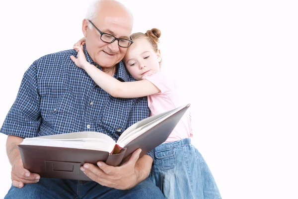 Grootvader lezen van een boek met kleindochter — Stockfoto