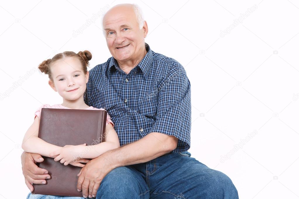 Grandfather reading a book with granddaughter