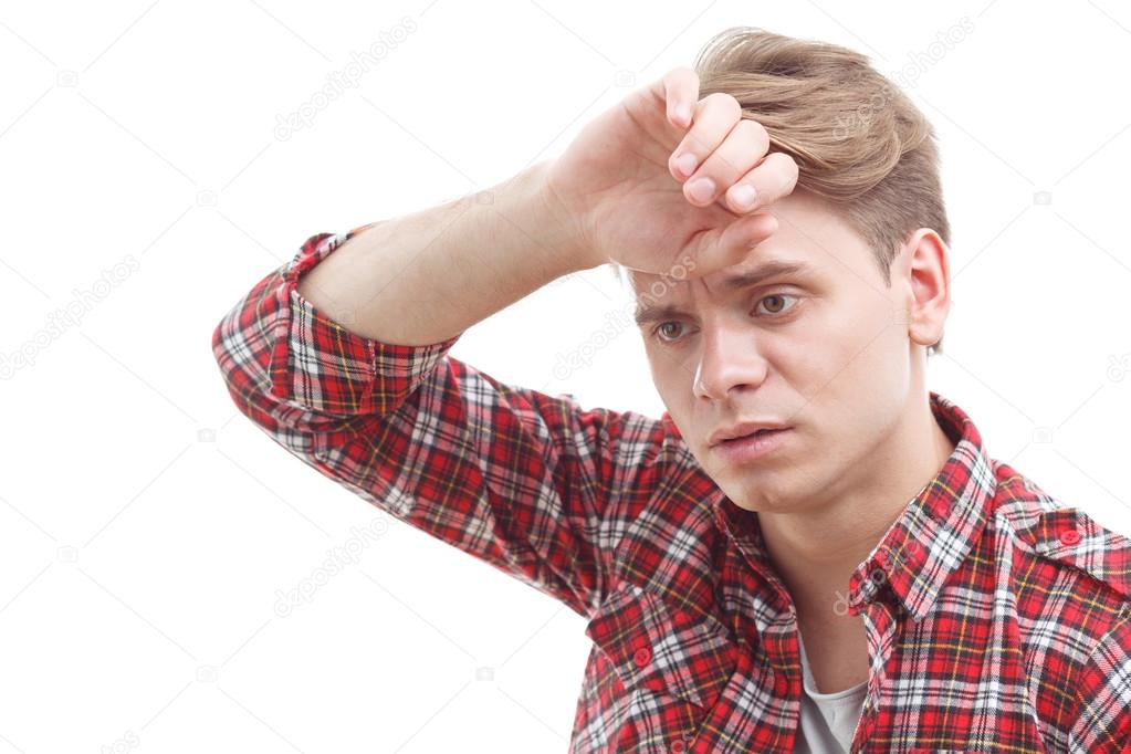 Exhausted guy holding his hand on the forehead.