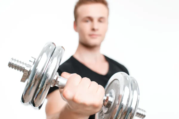 Na białym tle portret przystojny młodzieniec noszenie t-shirt czarny siedzi na piłkę fioletowy fitness z ręcznikiem na ramionach i trzymając butelkę wody po ciężkich treningów, — Zdjęcie stockowe