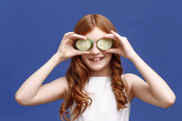 Menina segurando fatias de pepino — Fotografia de Stock