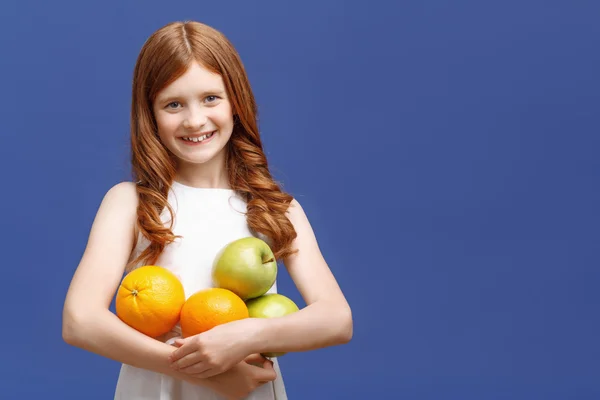Chica optimista sosteniendo frutas —  Fotos de Stock
