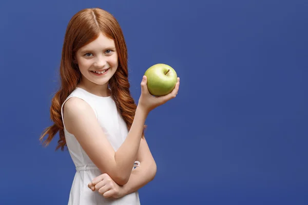 Miły dziewczynka trzymając w jednej ręce jabłko — Zdjęcie stockowe