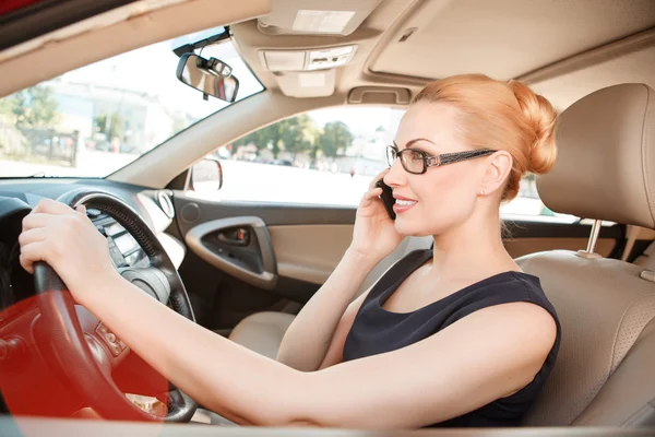 Zakenvrouw die mobiele telefoon in de auto gebruikt — Stockfoto